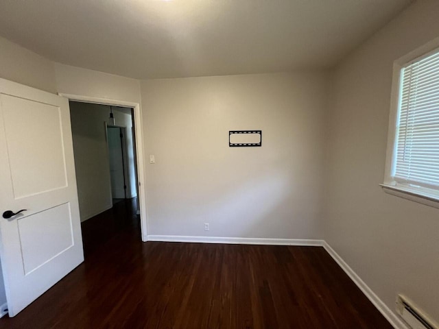 3668 S 79th St, Milwaukee, WI 53220 - unfurnished room featuring a baseboard heating unit and dark wood-style floors