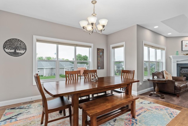 4790 Innovation Dr, Deforest, WI 53532 - dining area featuring a chandelier, light wood-type flooring, a glass covered fireplace, and recessed lighting