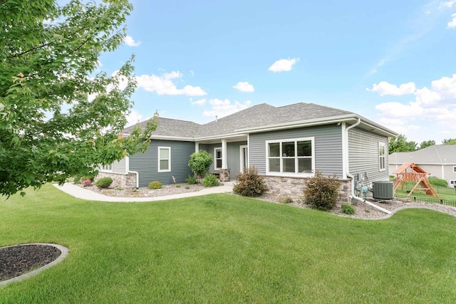 4790 Innovation Dr, Deforest, WI 53532 - view of front of property featuring stone siding, a playground, a front lawn, and roof with shingles