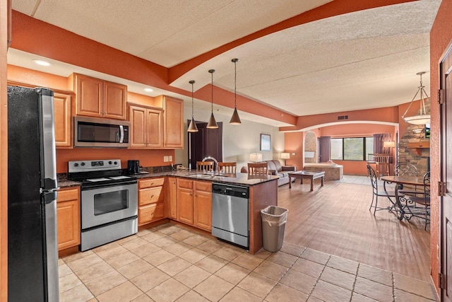 2411 River Rd Unit 2311, Wisconsin Dells, WI 53965 - kitchen with stainless steel appliances, open floor plan, a peninsula, hanging light fixtures, and arched walkways