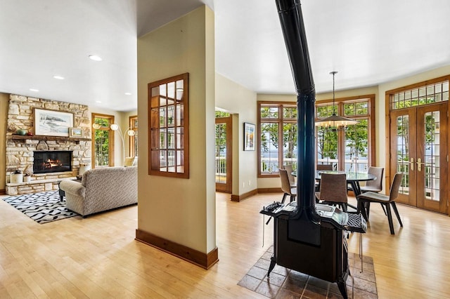 1124 Garrett Bay Rd, Ellison Bay, WI 54210 - dining space featuring french doors, light wood finished floors, a stone fireplace, and recessed lighting