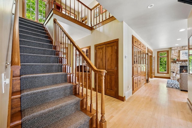1124 Garrett Bay Rd, Ellison Bay, WI 54210 - stairs featuring hardwood / wood-style flooring, healthy amount of natural light, recessed lighting, and a stone fireplace