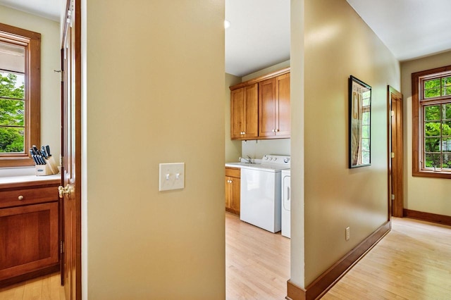 1124 Garrett Bay Rd, Ellison Bay, WI 54210 - laundry room with cabinet space, light wood-style flooring, and separate washer and dryer