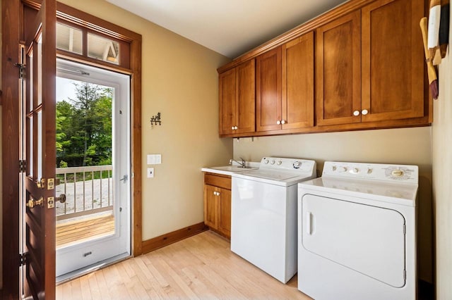 1124 Garrett Bay Rd, Ellison Bay, WI 54210 - washroom with cabinet space, washing machine and clothes dryer, and light wood-type flooring