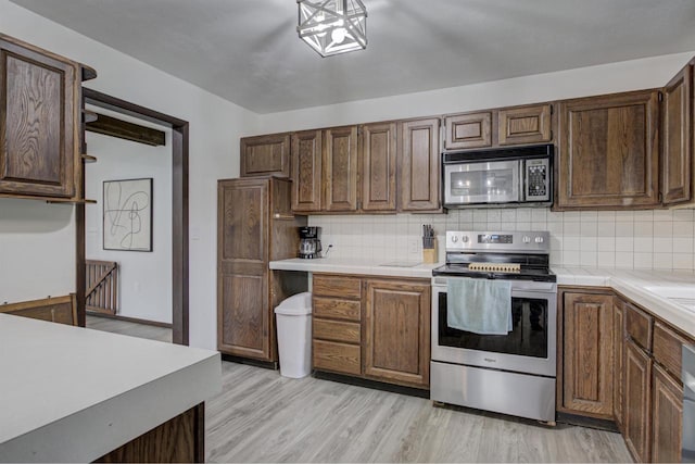 N9695 Willard Rd, Berlin, WI 54923 - kitchen featuring appliances with stainless steel finishes, backsplash, tile counters, and light wood-type flooring