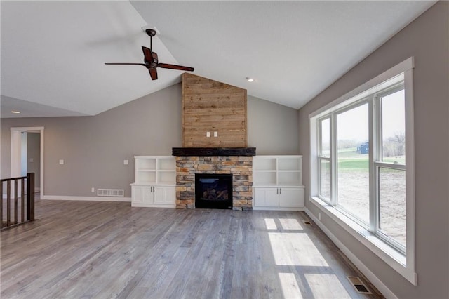 397 Candy Ln, River Falls, WI 54022 - unfurnished living room featuring wood finished floors, ceiling fan, high vaulted ceiling, a stone fireplace, and recessed lighting