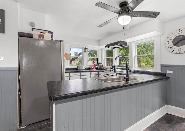 152 Hoyt St, Fond Du Lac, WI 54935 - kitchen with freestanding refrigerator, healthy amount of natural light, dark countertops, a peninsula, and wainscoting