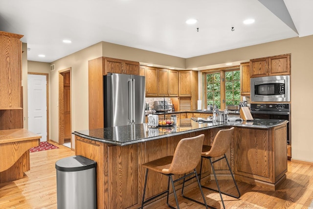2621 Russet Dr, Plover, WI 54467 - kitchen with appliances with stainless steel finishes, backsplash, brown cabinets, a spacious island, and recessed lighting