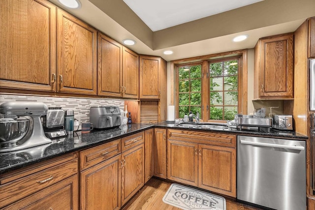 2621 Russet Dr, Plover, WI 54467 - kitchen with dishwasher, brown cabinetry, tasteful backsplash, dark stone countertops, and light wood finished floors