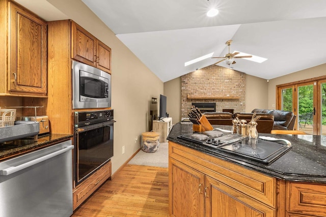 2621 Russet Dr, Plover, WI 54467 - kitchen with black appliances, light wood-style floors, a skylight, a ceiling fan, and open floor plan