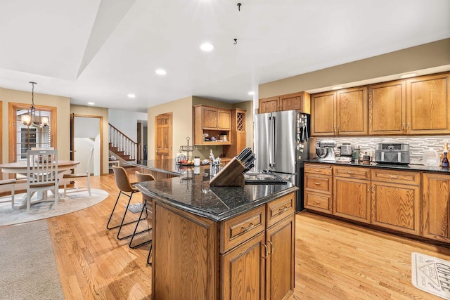 2621 Russet Dr, Plover, WI 54467 - kitchen featuring freestanding refrigerator, brown cabinets, a kitchen breakfast bar, and recessed lighting