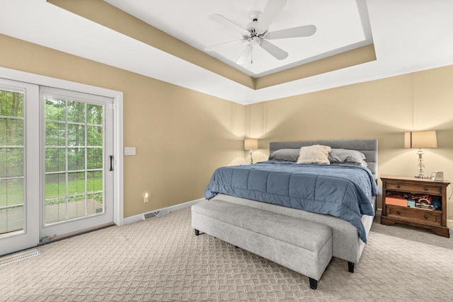 2621 Russet Dr, Plover, WI 54467 - bedroom featuring light colored carpet, a tray ceiling, access to exterior, and a ceiling fan