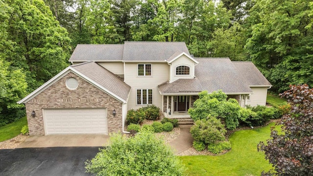 2621 Russet Dr, Plover, WI 54467 - view of front of house with driveway, a garage, brick siding, a front lawn, and roof with shingles