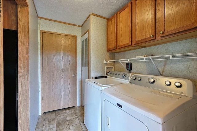 2329 Sand Rd, Shell Lake, WI 54871 - laundry room featuring washing machine and clothes dryer, cabinet space, a textured ceiling, and light tile patterned floors