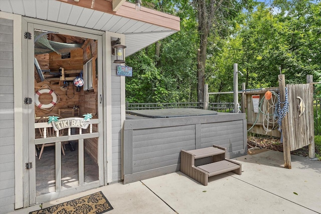 110 Chestnut Way, North Prairie, WI 53153 - doorway to property featuring a hot tub, a patio area, and view of wooded area