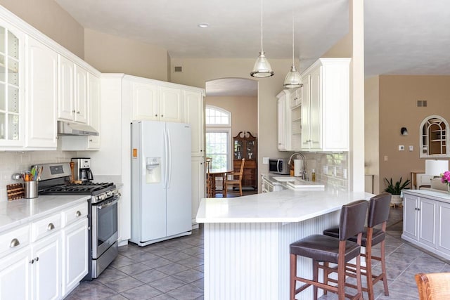 3864 Candlish Harbor Ln, Oshkosh, WI 54902 - kitchen with stainless steel appliances, under cabinet range hood, arched walkways, and decorative backsplash