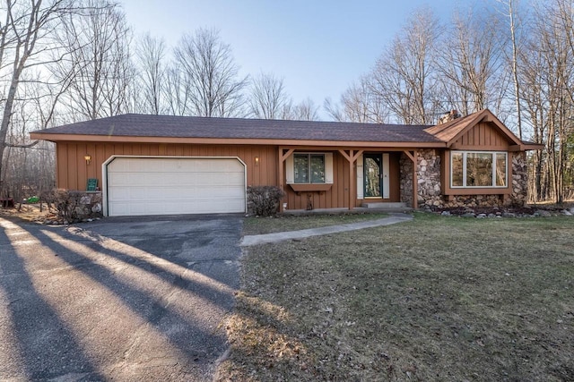 8420 Southview Dr, Crandon, WI 54520 - view of front of house featuring asphalt driveway, stone siding, board and batten siding, and an attached garage