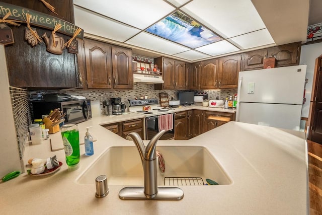 8420 Southview Dr, Crandon, WI 54520 - kitchen featuring white appliances, under cabinet range hood, decorative backsplash, light countertops, and dark brown cabinetry