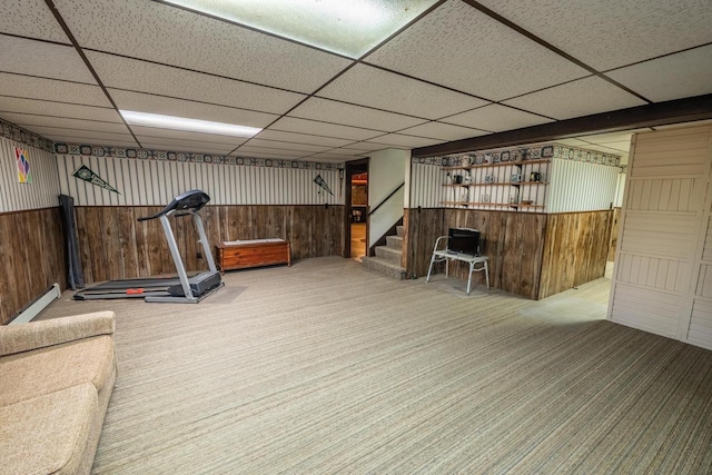 8420 Southview Dr, Crandon, WI 54520 - exercise room featuring carpet flooring, wood walls, a paneled ceiling, and a baseboard radiator