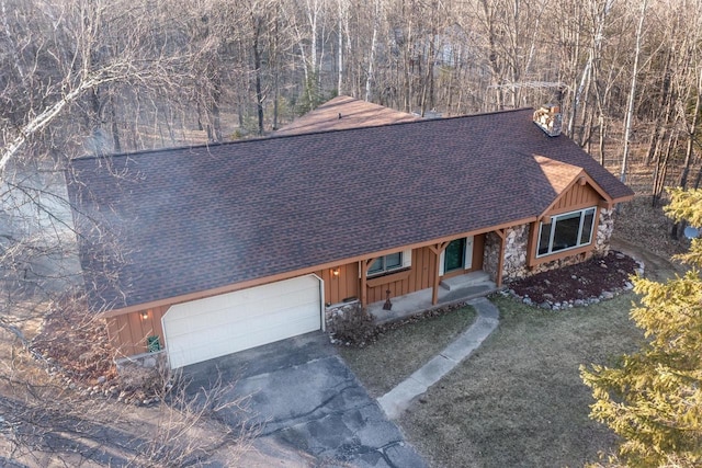 8420 Southview Dr, Crandon, WI 54520 - view of front of house with board and batten siding, a shingled roof, an attached garage, and concrete driveway
