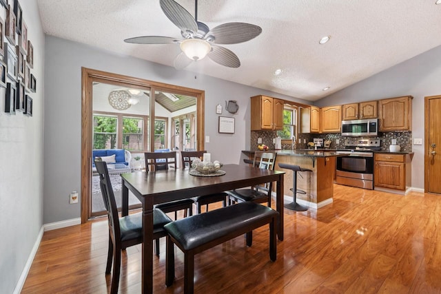 1434 Alcan Dr, Menasha, WI 54952 - dining area with a textured ceiling, lofted ceiling, light wood-type flooring, and ceiling fan