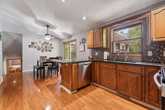 1434 Alcan Dr, Menasha, WI 54952 - kitchen featuring stainless steel appliances, a textured ceiling, a peninsula, light wood finished floors, and backsplash