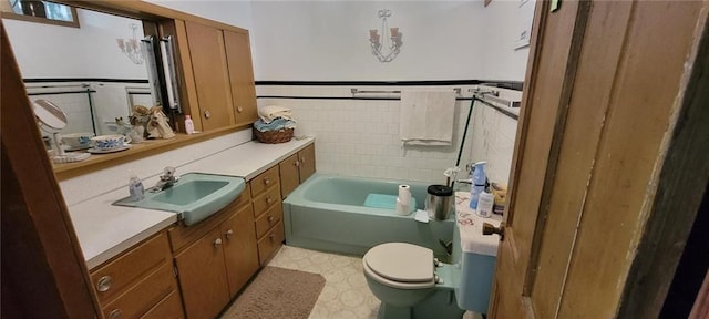 N3598 Nichols Rd, Black River Falls, WI 54615 - bathroom featuring vanity, a tub to relax in, tile patterned floors, and a wainscoted wall