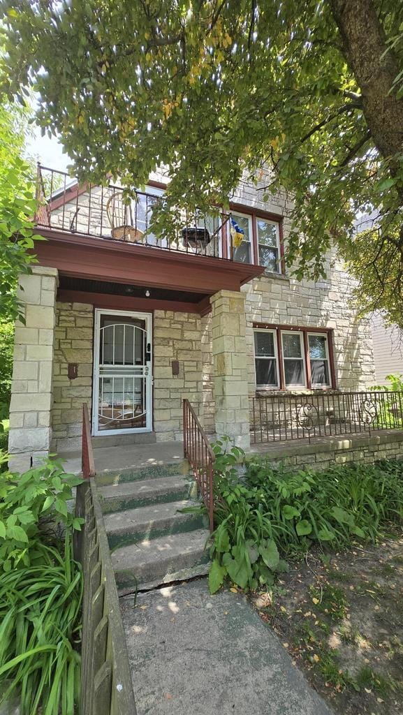 3240 N Richards St Unit 3242, Milwaukee, WI 53212 - view of front facade featuring a balcony, stone siding, and a porch