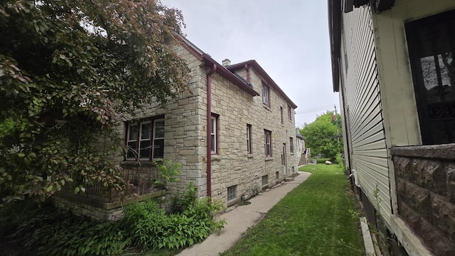 3240 N Richards St Unit 3242, Milwaukee, WI 53212 - view of home's exterior featuring stone siding and a lawn