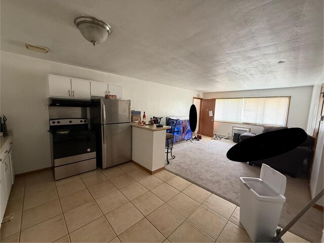 2338 Allied Dr Unit 4, Madison, WI 53711 - kitchen featuring appliances with stainless steel finishes, white cabinets, light tile patterned floors, under cabinet range hood, and open floor plan