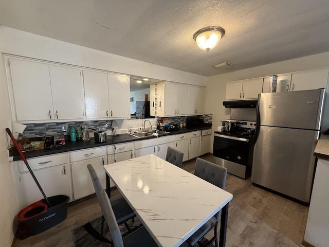 2342 Allied Dr Unit 1, Madison, WI 53711 - kitchen featuring appliances with stainless steel finishes, under cabinet range hood, dark wood finished floors, backsplash, and a textured ceiling