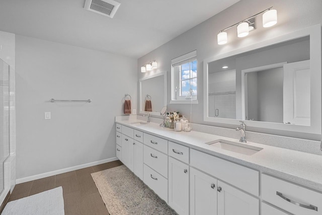 7845 W Mourning Dove Ln, Mequon, WI 53097 - bathroom featuring double vanity, tiled shower, and wood finished floors