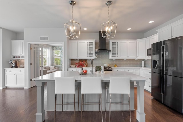 7845 W Mourning Dove Ln, Mequon, WI 53097 - kitchen with freestanding refrigerator, wall chimney range hood, light countertops, backsplash, and a chandelier