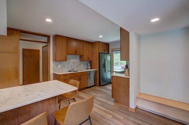 5043 Marathon Dr, Madison, WI 53705 - kitchen with stainless steel appliances, light countertops, light wood-style floors, brown cabinetry, and backsplash