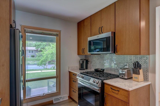 5043 Marathon Dr, Madison, WI 53705 - kitchen with stainless steel appliances, healthy amount of natural light, tasteful backsplash, and brown cabinets