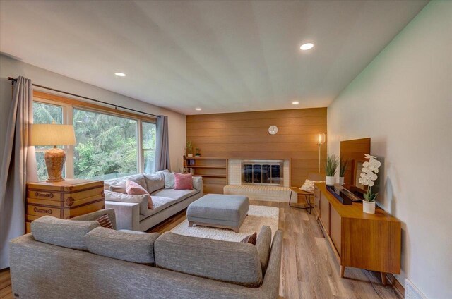 5043 Marathon Dr, Madison, WI 53705 - living room featuring light wood finished floors, recessed lighting, a brick fireplace, and wood walls