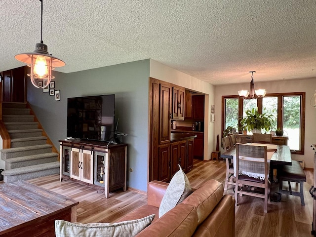 5116 S 84th St, Greendale, WI 53129 - living room with light wood-style floors, a chandelier, stairway, and a textured ceiling