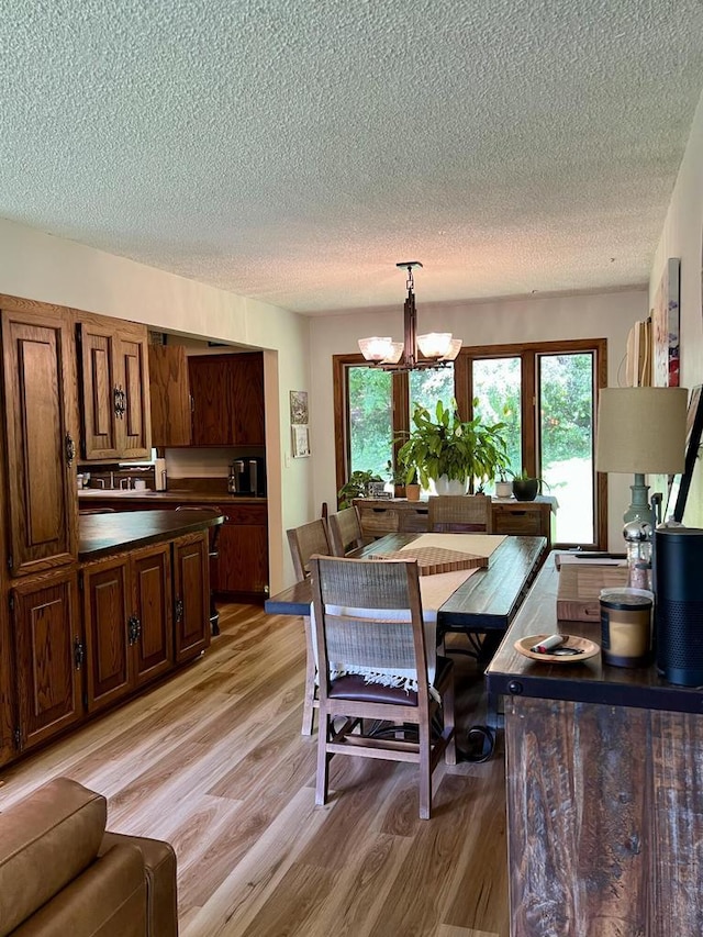 5116 S 84th St, Greendale, WI 53129 - dining area with a textured ceiling, light wood-style floors, and a chandelier
