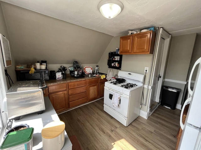 2928 N Humboldt Blvd Unit 2930, Milwaukee, WI 53212 - kitchen with white appliances, wood finished floors, brown cabinetry, and vaulted ceiling