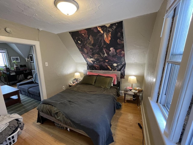 2928 N Humboldt Blvd Unit 2930, Milwaukee, WI 53212 - bedroom with light wood-type flooring, lofted ceiling, a textured wall, and a textured ceiling