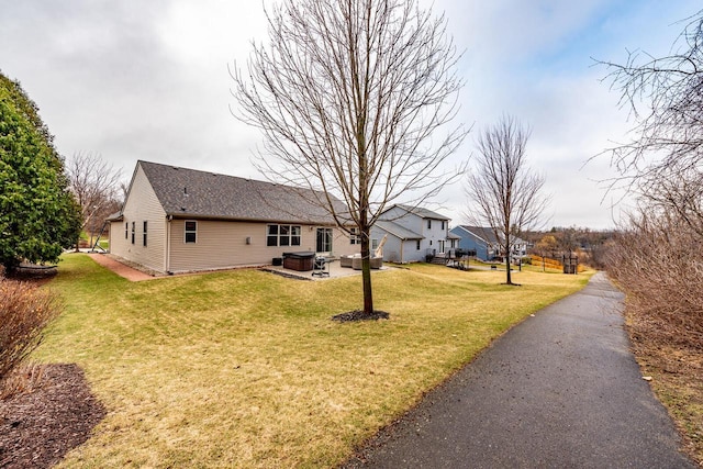 431 Thurow Dr, Oconomowoc, WI 53066 - view of front of property featuring a hot tub, a front lawn, roof with shingles, and a patio area