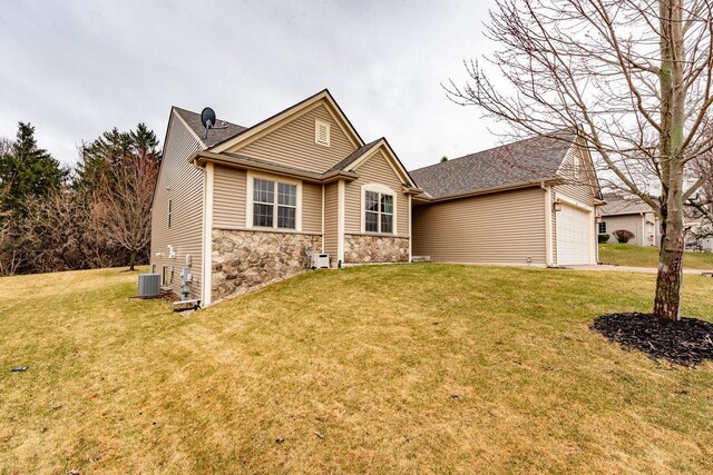 431 Thurow Dr, Oconomowoc, WI 53066 - view of front of house with stone siding, a front yard, a garage, and concrete driveway