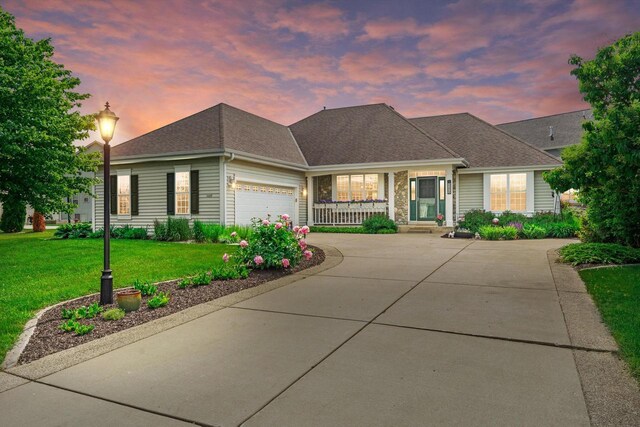 3259 Emmertsen Rd, Racine, WI 53406 - view of front facade with a porch, a front yard, concrete driveway, and an attached garage