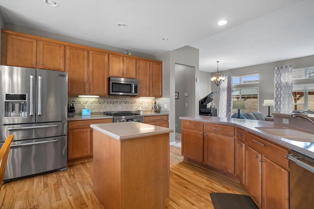 3259 Emmertsen Rd, Racine, WI 53406 - kitchen featuring stainless steel appliances, light wood-style floors, brown cabinetry, a chandelier, and recessed lighting