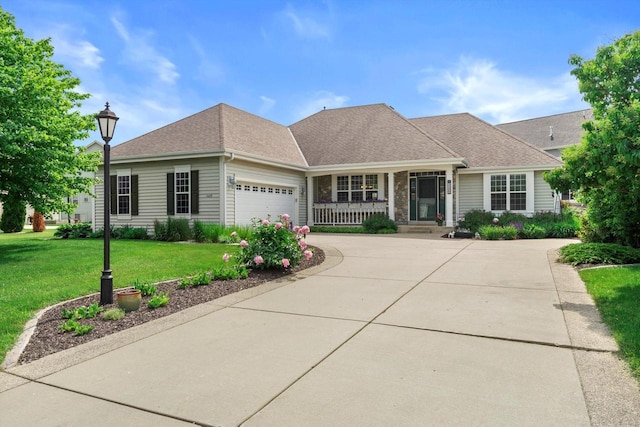 3259 Emmertsen Rd, Racine, WI 53406 - view of front of home featuring covered porch, a front yard, a garage, driveway, and a shingled roof