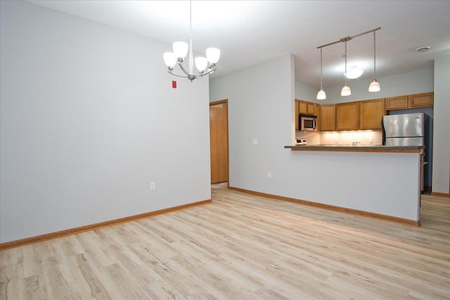 6701 Fairhaven Rd Unit 202, Madison, WI 53719 - kitchen featuring stainless steel appliances, light wood-type flooring, brown cabinets, and a chandelier