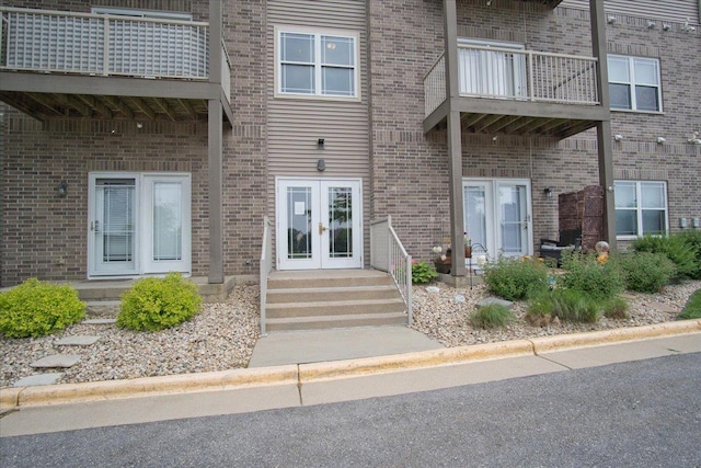 6701 Fairhaven Rd Unit 202, Madison, WI 53719 - doorway to property featuring french doors, a balcony, and brick siding