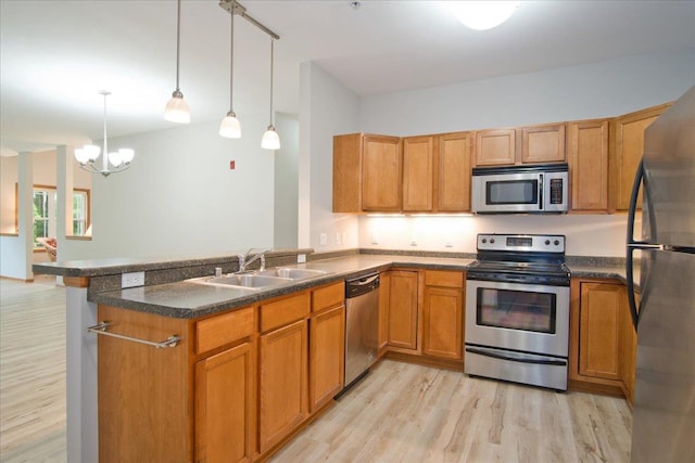 6701 Fairhaven Rd Unit 202, Madison, WI 53719 - kitchen featuring appliances with stainless steel finishes, a peninsula, light wood-type flooring, and dark countertops