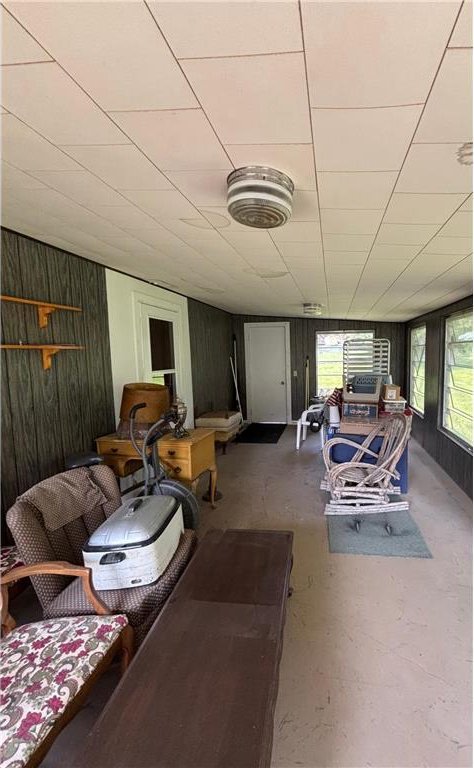 306 Pleasant Ave, Frederic, WI 54837 - living room featuring wood walls and concrete floors