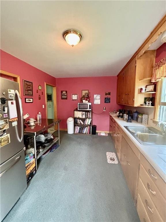 306 Pleasant Ave, Frederic, WI 54837 - kitchen with stainless steel appliances, light countertops, carpet flooring, open shelves, and brown cabinets